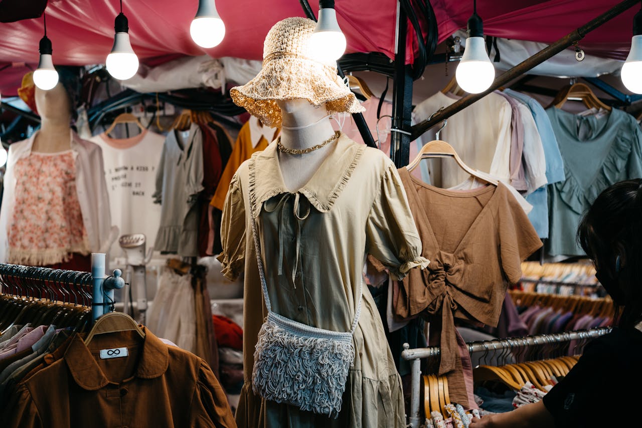 A bustling street market showcasing trendy, diverse clothing under vibrant lighting.