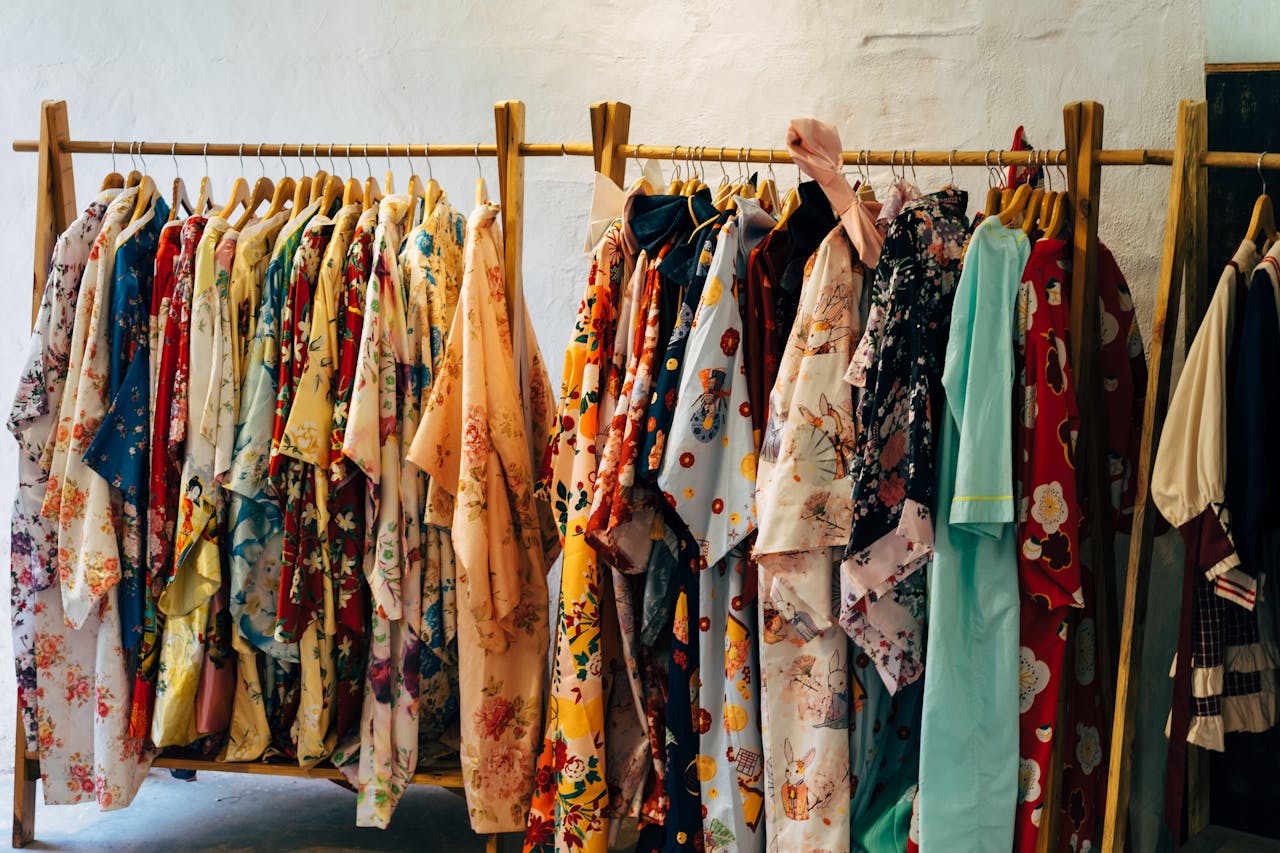A vibrant display of floral kimonos hanging on wooden racks in a boutique setting.